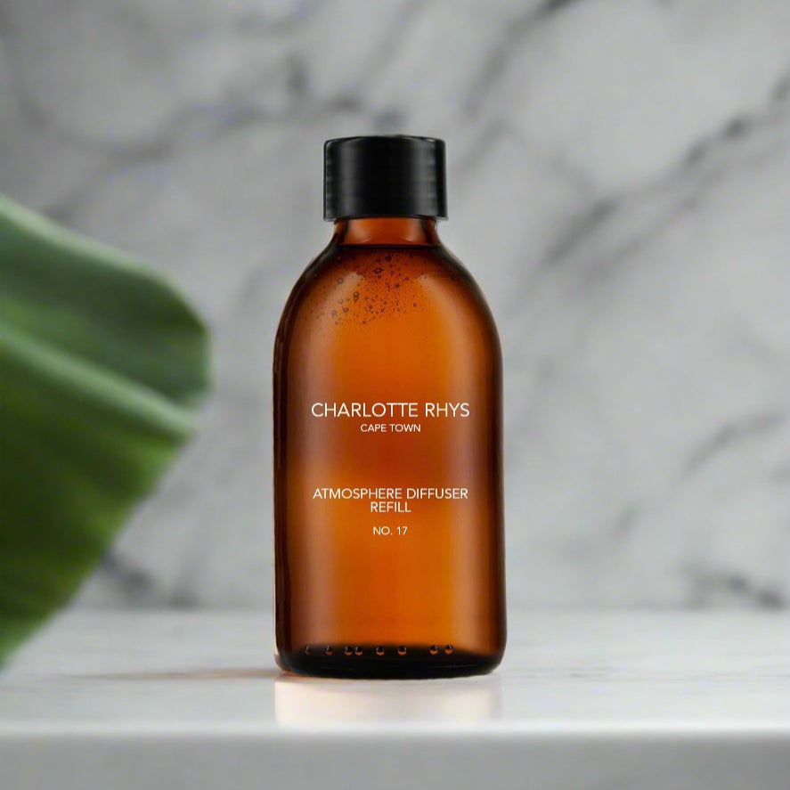 200ml-Atmosphere-Diffuser-Refill-No-17 A brown glass bottle labeled 'charlotte rhys atmosphere diffuser refill' with a capacity of 1 litre, placed on a marble surface with a plant in the background.