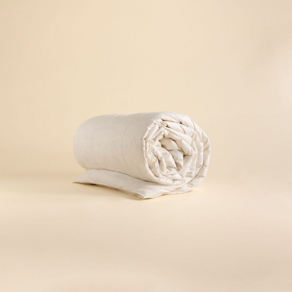 A folded beige duvet cover on a neutral background.