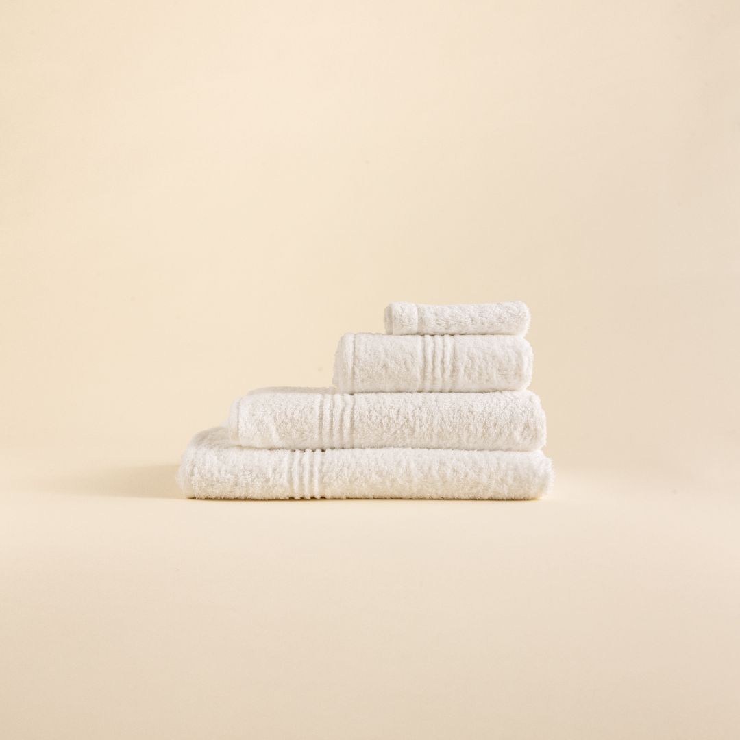 MerakiTowels Stack of white towels in various sizes on a beige background